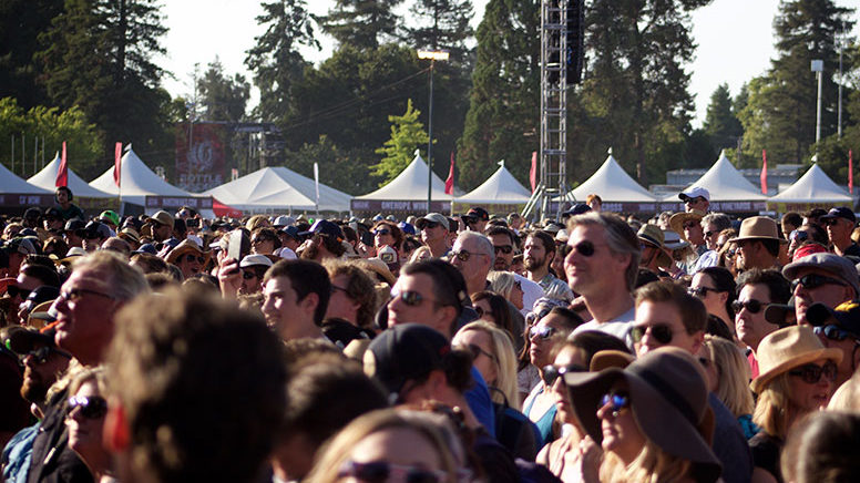 a photo of a large crowd at an outdoor concert event with Made in the Shade tents in the background lining the skyline