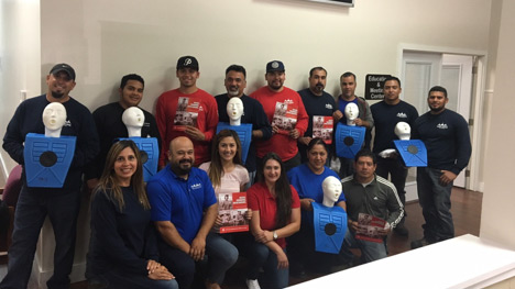 An image of the Made in the Shade crew gathered together and standing with CPR dummies