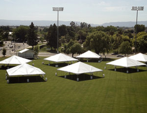 An image of tents on a green lawn